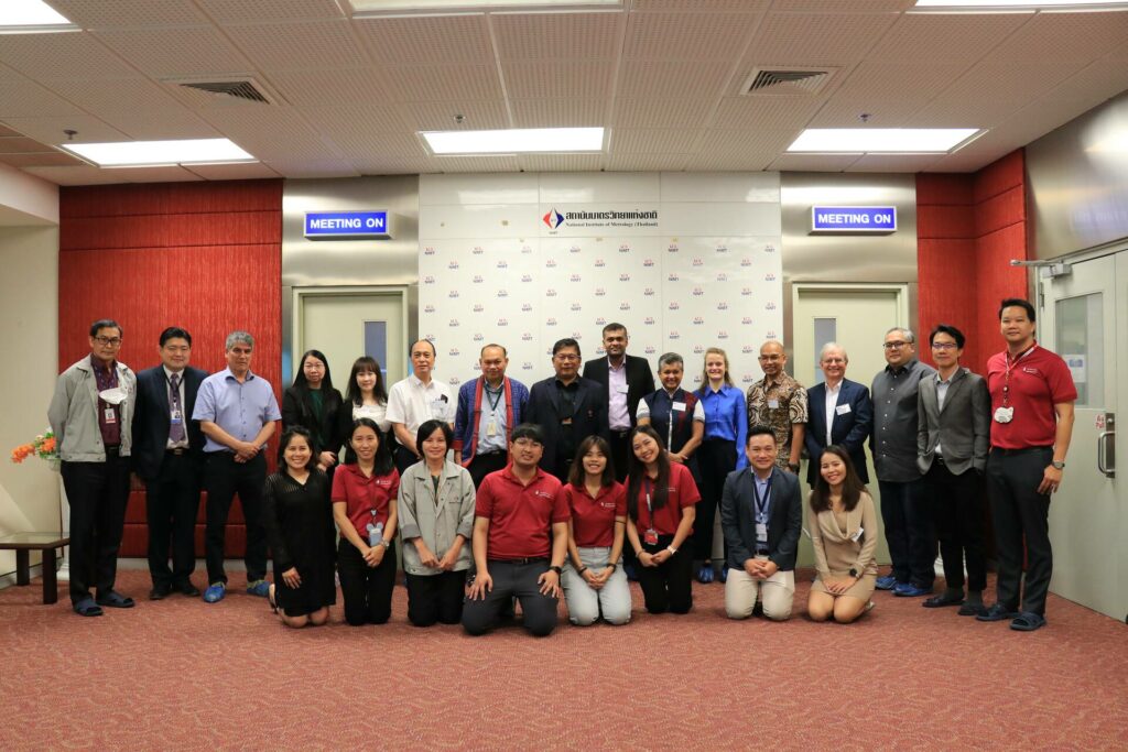 A group of 24 women and men in a corridor